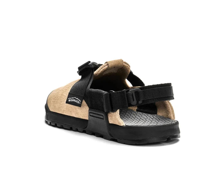 Tan and black sandal with a brand logo on a white background