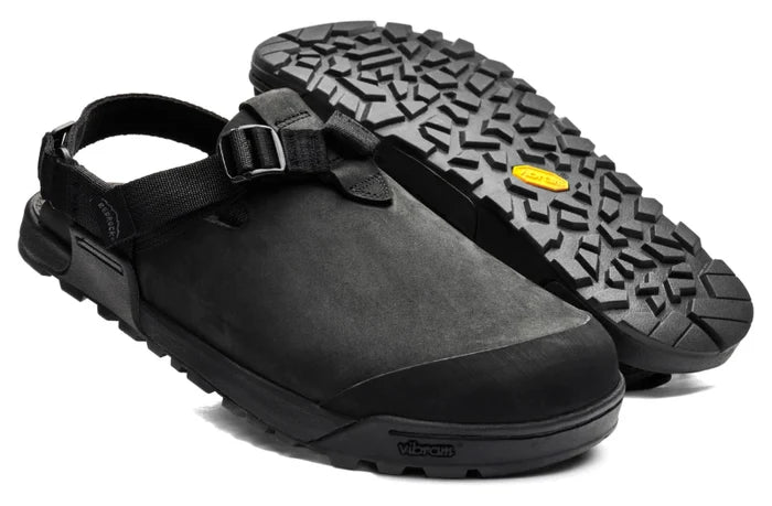 Black clog shoes with a textured sole on a white background