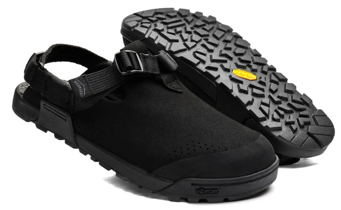 Black clog-style shoes with a textured sole on a white background