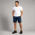 A man wearing a high quality navy blue athletic shorts stretchable material with a small white Dominance logo on the left leg, and black sneakers, standing