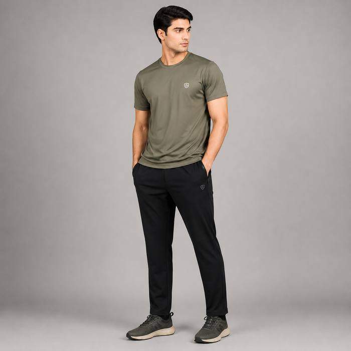 A man modeling a quick dry short-sleeve crewneck t-shirt in olive green, paired with black pants and gray sneakers.