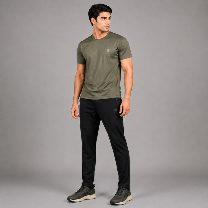 A man modeling an olive green short-sleeve athletic t-shirt and black athletic pants against a solid gray studio background.