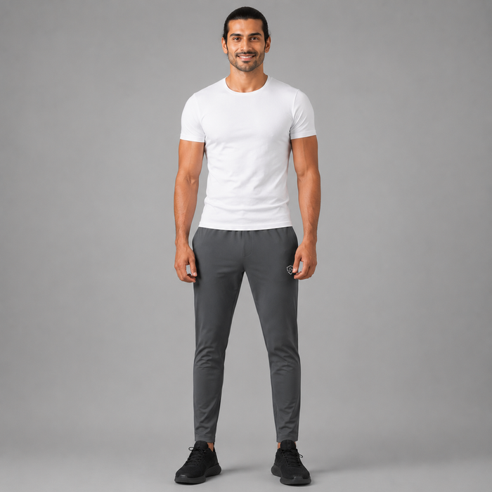 A man modeling a Charcoal gray trousers against a solid gray studio background.