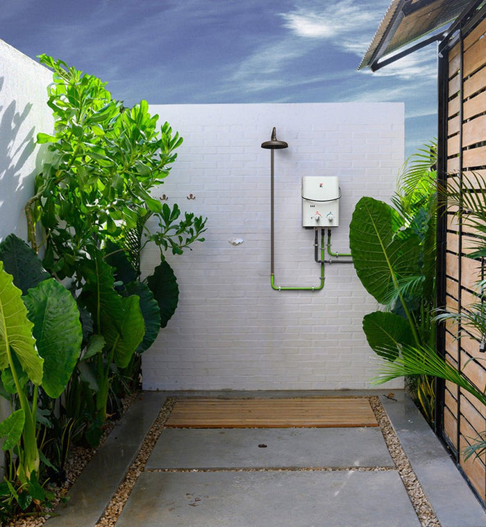 Outdoor Tropical White Brick Wall Shower Setup With Mounted Tankless Water Heater And Wooden Floor Mat
