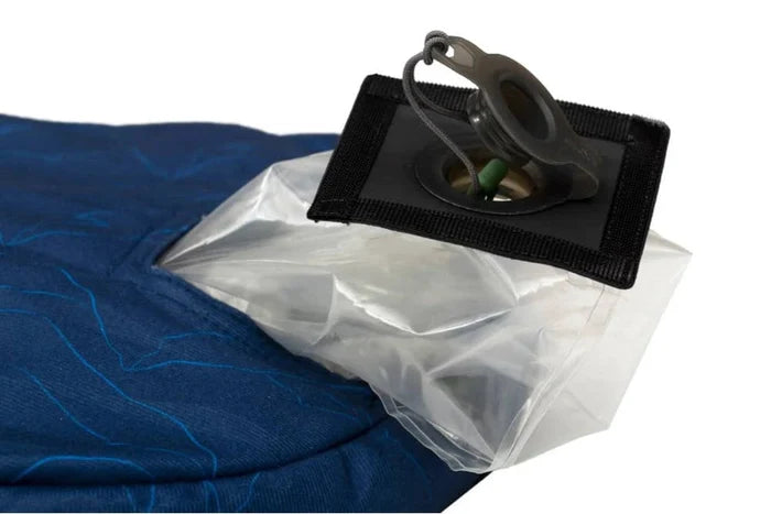 Close-up of a blue pillow with a white plastic bag and black clip on a white background
