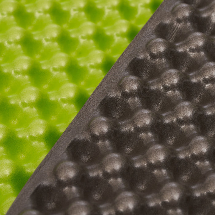 Close-up of a hiking sit pad mat surface with a green background