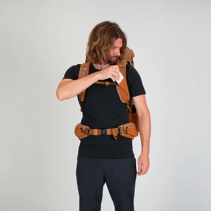 Man wearing a brown backpack on a plain background