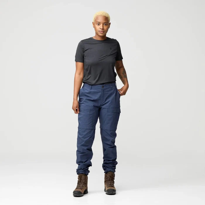 Person wearing a dark gray t-shirt and blue pants on a white background