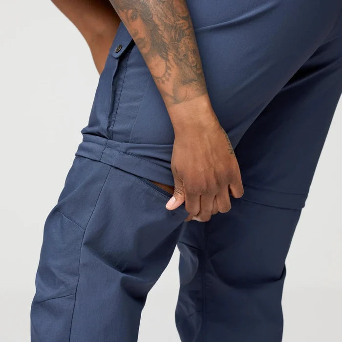 Person wearing navy blue pants with a plain background