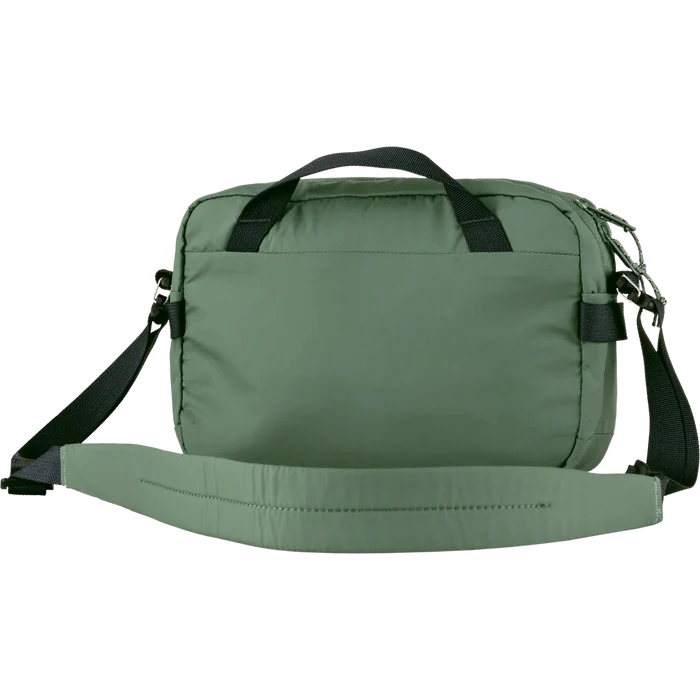 Green bag with black straps on a white background