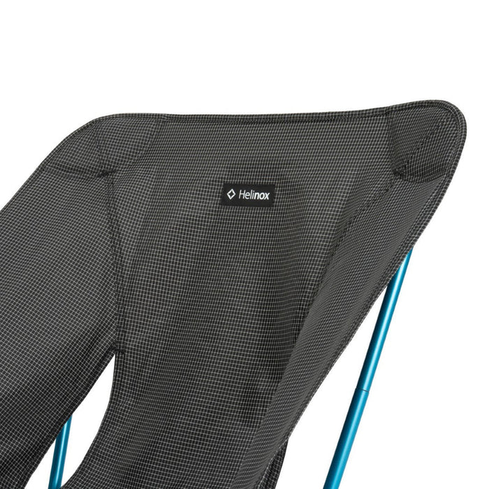 Black Helinox chair with blue legs on a white background