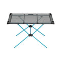 Helinox Portable camping table with mesh top and blue legs on a white background