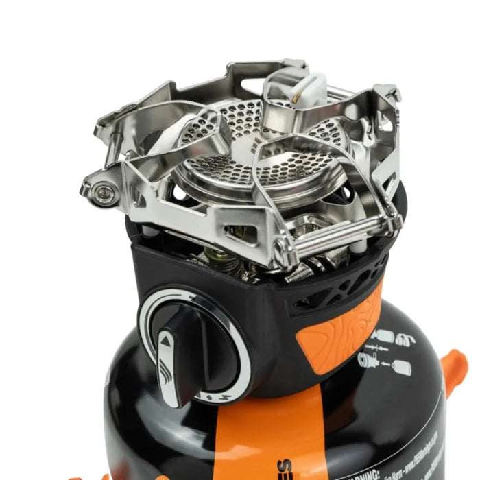 Close-up of a portable camping stove with orange and black design on a white background