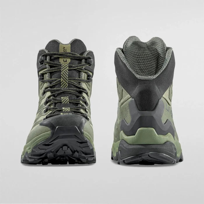 Green hiking boots with black soles on a light gray background