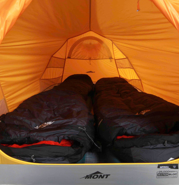 inside of a orange tent with two black sleeping bags