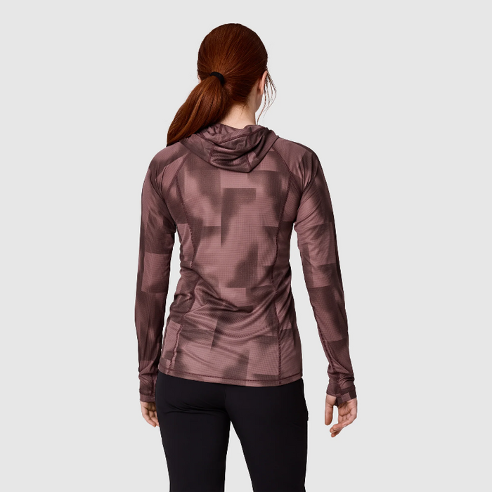 A woman viewed from the back wearing a long-sleeve athletic hoodie with a tonal geometric pattern in dusty rose and mauve, paired with black leggings, against a light gray studio background.