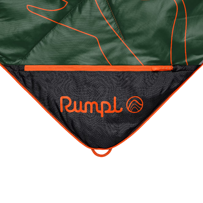 Close-up of a camping sleeping bag or tent showing a dark green outer fabric with orange piping and a black inner panel printed with the orange Rumpl logo.