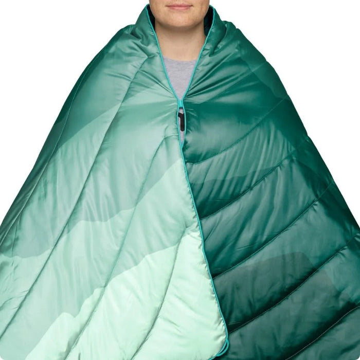 Person wrapped in a teal quilt on a white background