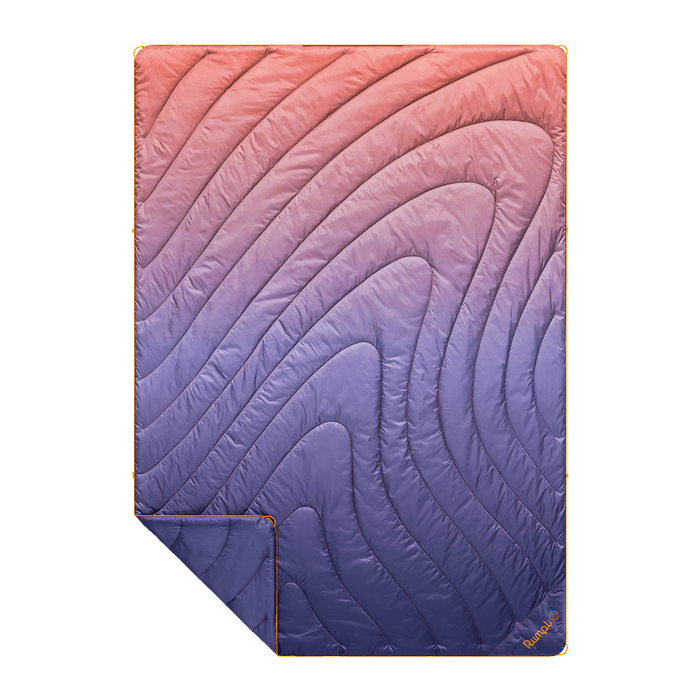 Gradient quilted blanket transitioning from pink to purple on a black background
