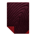 Maroon quilt with wavy pattern on a white background