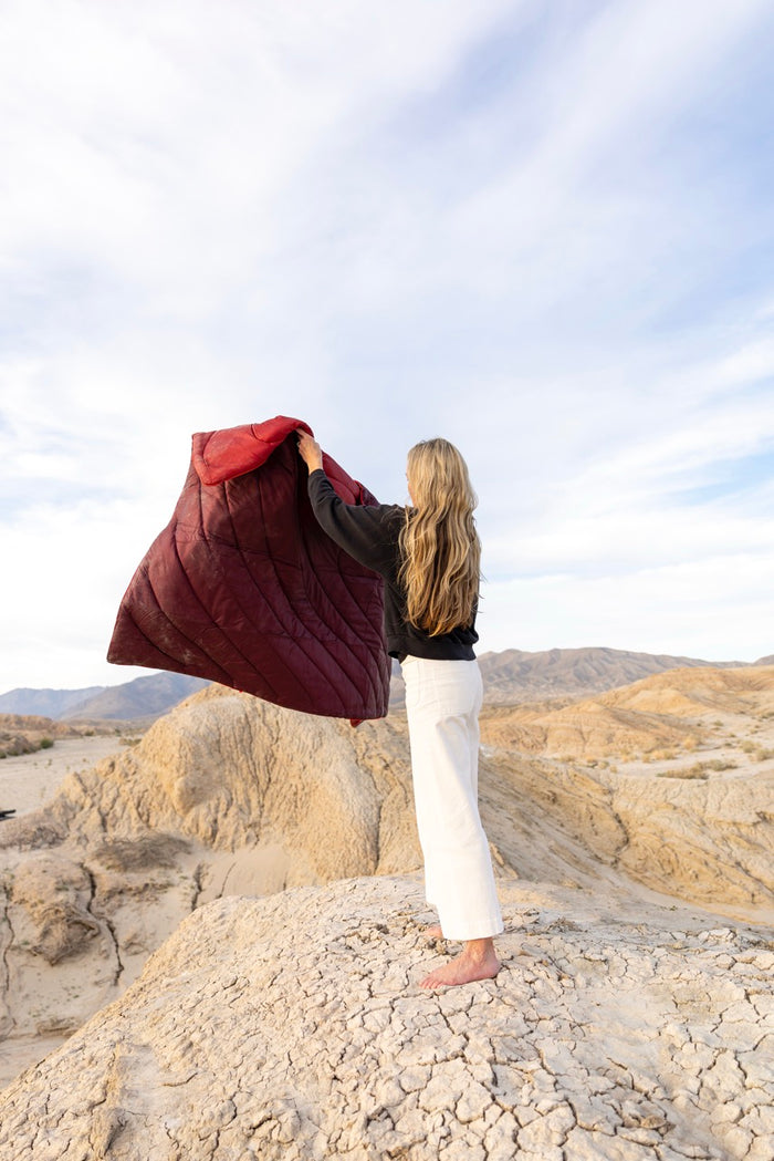 Woman holding a rumpl waterproof blanket australia