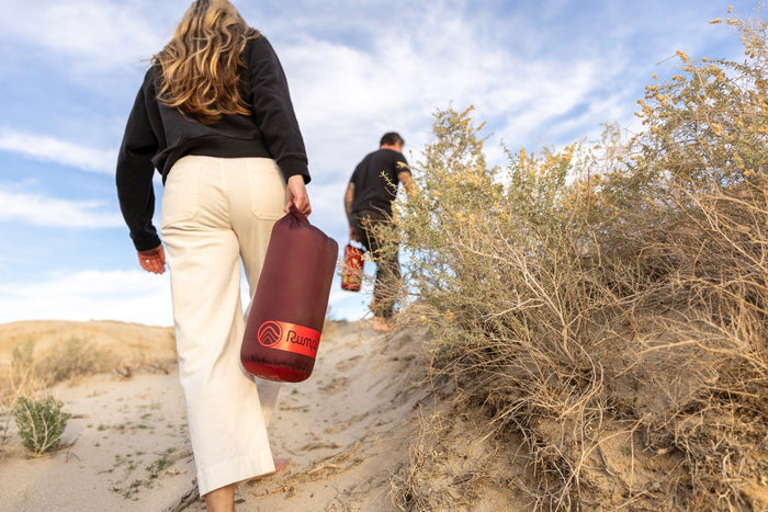Two people bushwalking in australia with a maroon rumpl waterproof travel blanket