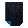 A dark navy quilted sleeping pad with a wavy, flowing pattern of stitching, shown with a corner folded over to reveal a bright blue backing on a solid white background.