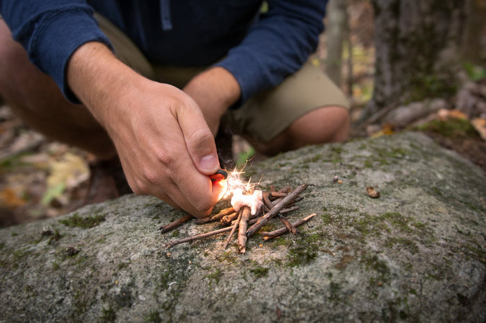 Ferro rod and tinder used on a rod to light a bunch of sticks