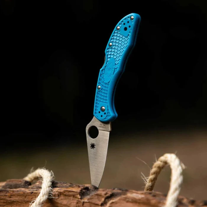 Folding knife with a blue handle on a wooden surface
